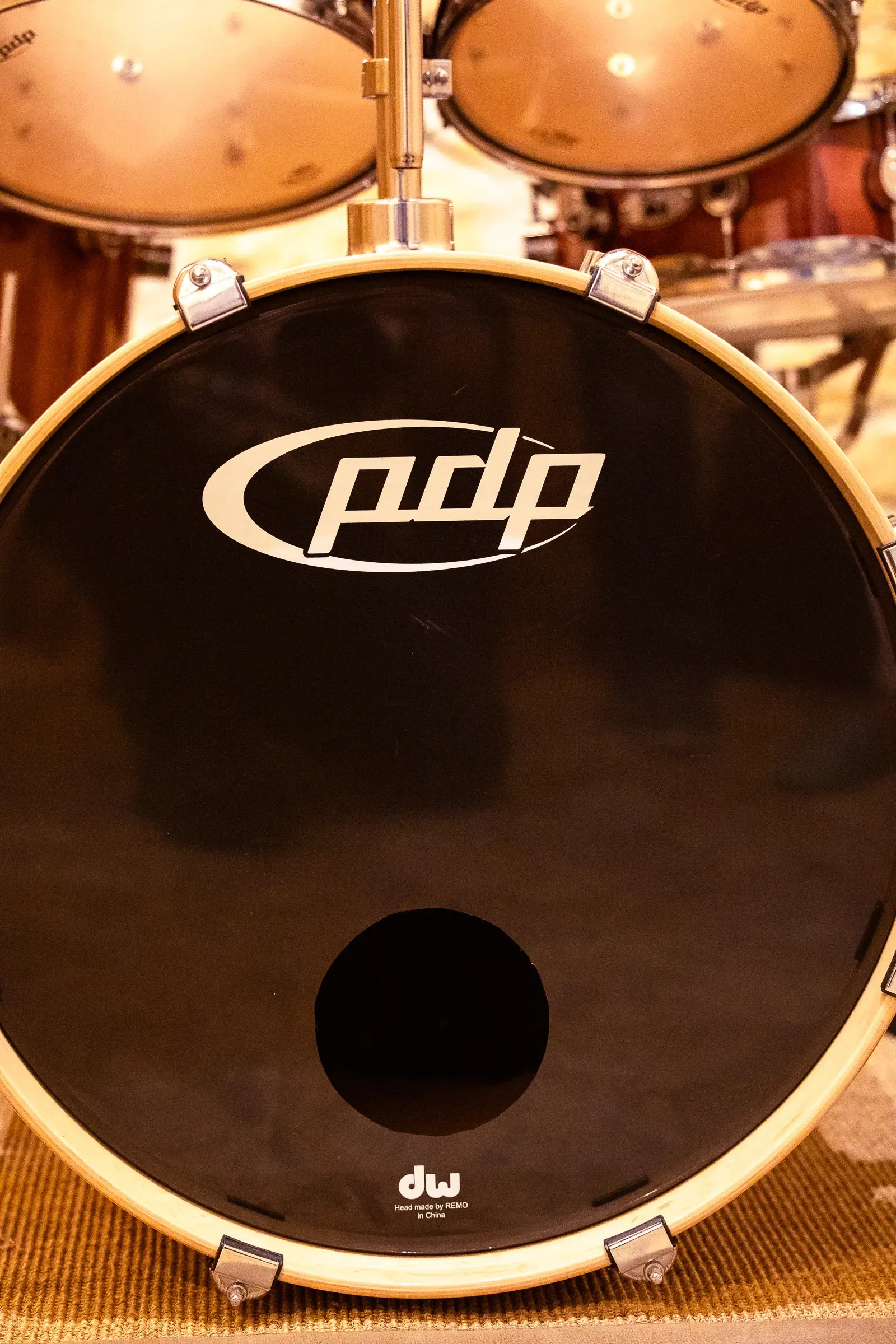PDP bass drum front head — white PDP logo on black, DW branding at the bottom, Lyon