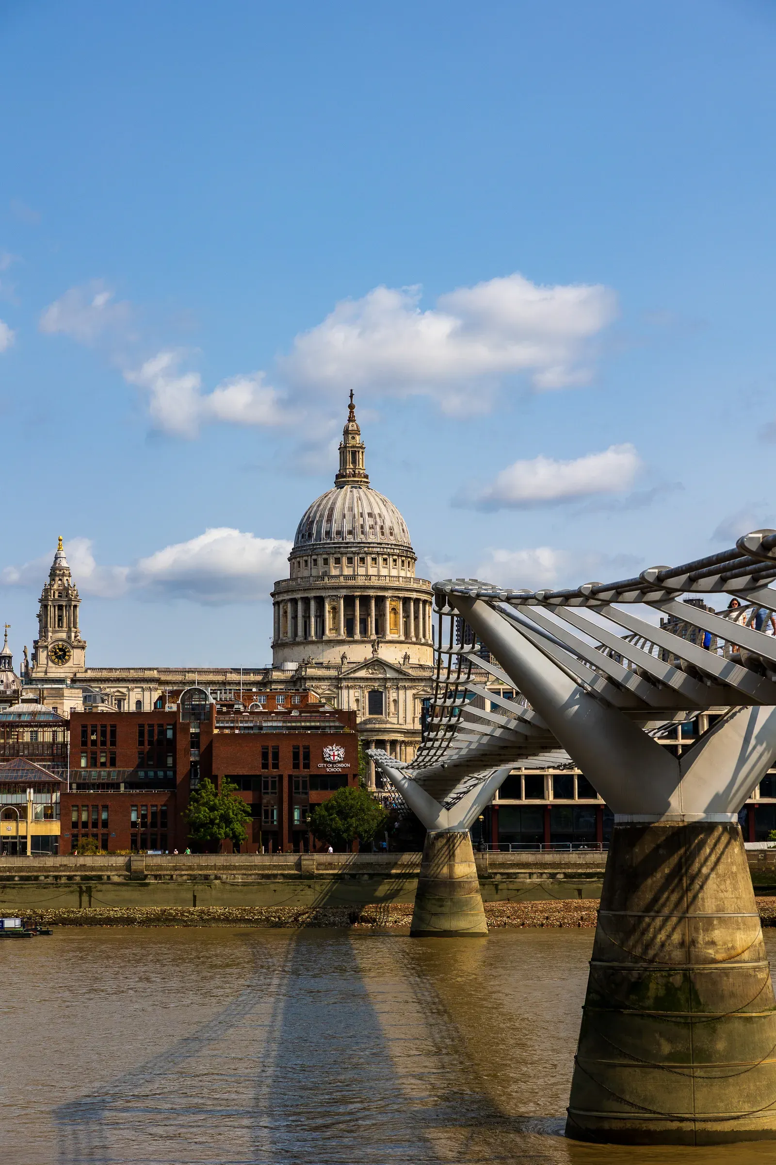 St Paul's Cathedral dome and the Millennium Bridge's cables, City of London School behind, blue sky