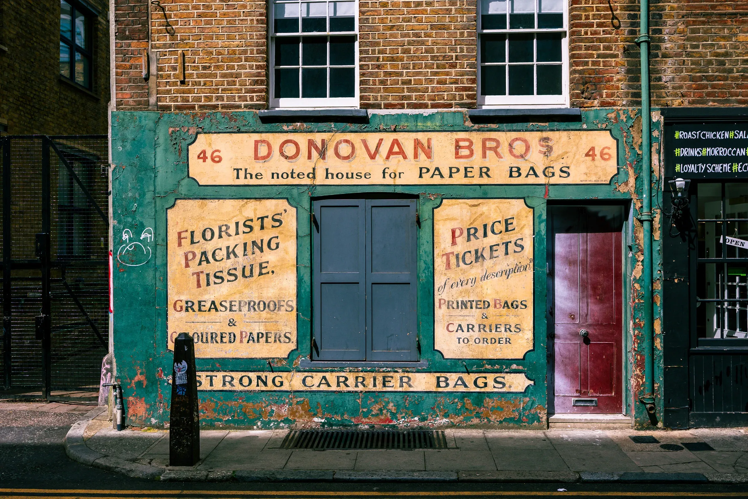 Donovan Bros' painted shopfront — green paintwork, gold lettering, a maroon door — on a red-brick building in London